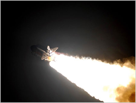 El Endeavour sobre la columna de fuego de su lanzamiento - NASA/Jerry Cannon, Rusty Backer