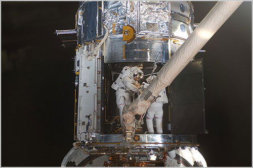 Mike Massimino y Michael Good trabajando en el interior del Hubble