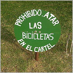 Cartel: «Prohibido atar las bicicletas en el cartel»