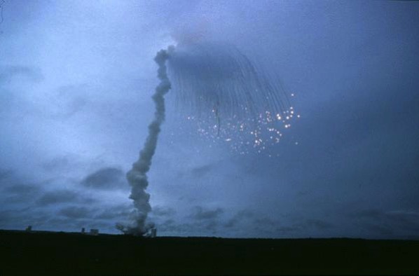 Los múltiples fragmentos resultantes de la explosión en vuelo del primer Ariane 5 abriéndose en abanico contra un cielo nublado